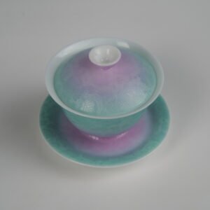 Top-angle view of the complete Spring Glow Gradient Elegant Charm Gaiwan set, showing the lid, cup, and saucer with a soft gradient blend of pink and fresh green glaze and handcrafted Pa Hua Hundred Flowers pattern