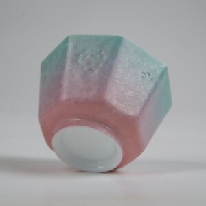 Bottom-up view of the Spring Glow Gradient Octagonal Glazed Linglong porcelain cup showcasing its white base, geometric facets, and soft green-to-pink gradient carved floral details