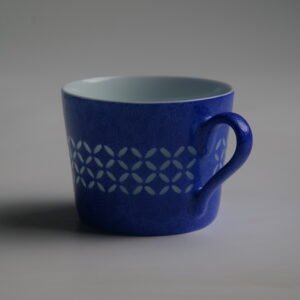 Side profile of ultramarine coffee cup with coin pattern