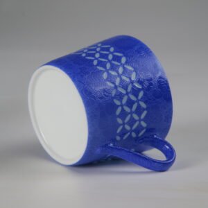 Tilted view of ultramarine coffee cup showing outer pattern and base