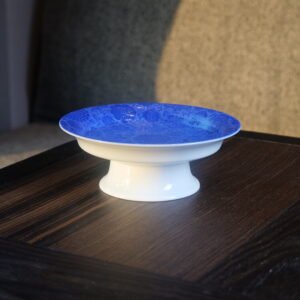 Side view of ultramarine porcelain plate showing white pedestal base
