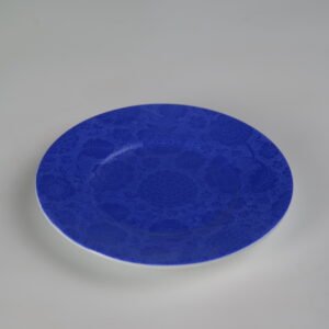 Top view of ultramarine porcelain saucer with carved floral pattern