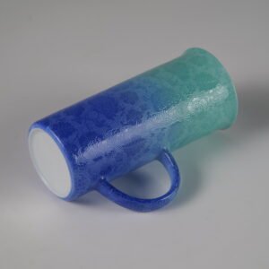 Tilted side view of verdant blue aroma cup showing carved pattern and base