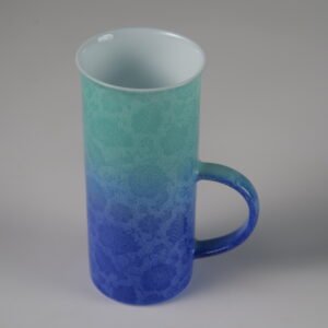 High angle view of tall verdant blue gradient porcelain coffee cup with handle