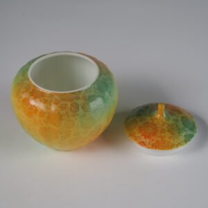 High angle view of open verdant clouds with orange hues melon jar showing white glazed interior