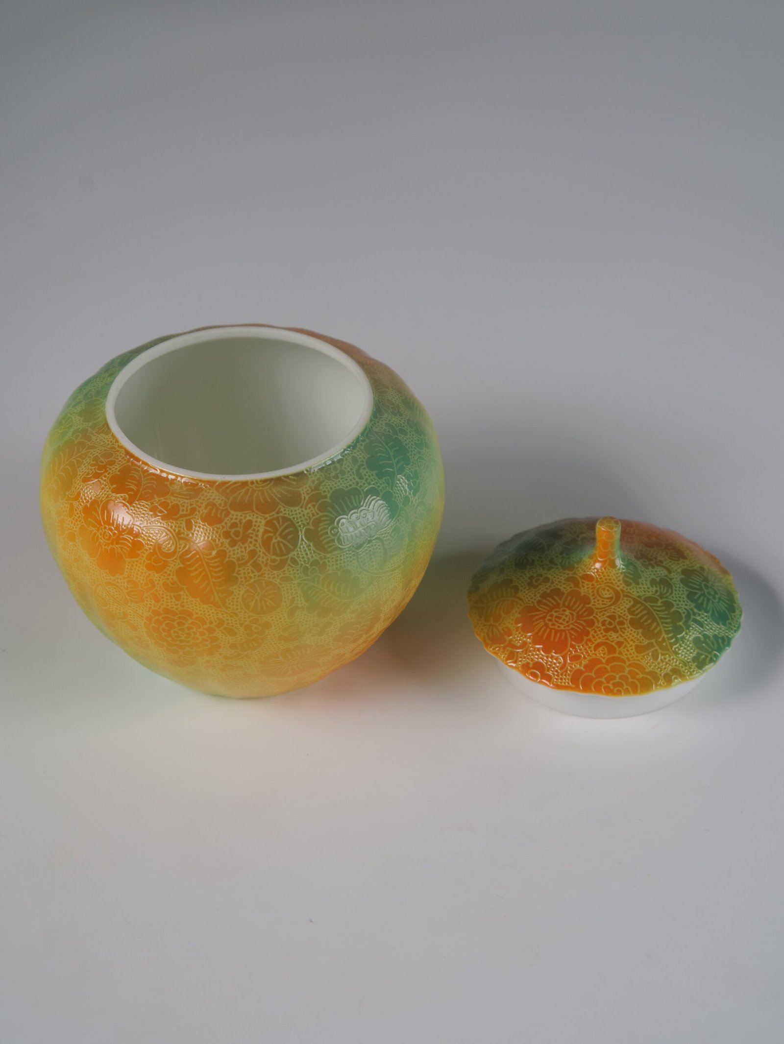 Verdant Clouds with Orange Hues Melon Jar – Interior View High angle view of open verdant clouds with orange hues melon jar showing white glazed interior