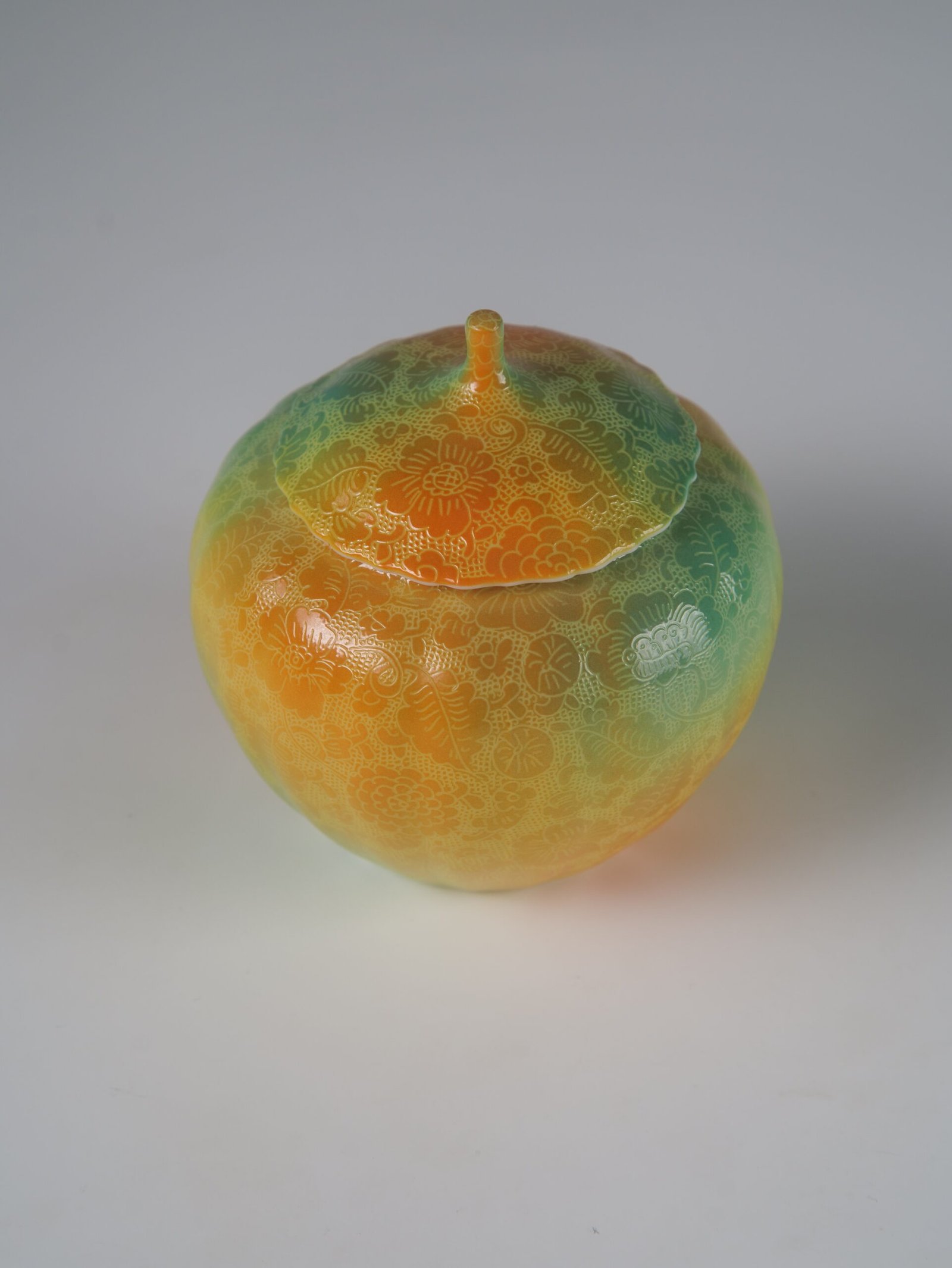 Verdant Clouds with Orange Hues Melon Jar – Top Angle Top view of verdant clouds with orange hues porcelain melon-shaped jar with lid
