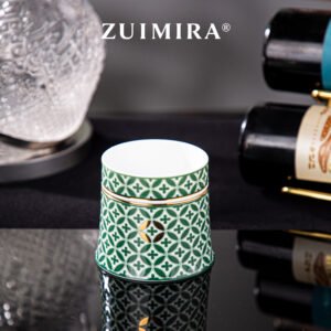 Green carved porcelain cup with four-leaf pattern on a glossy black surface